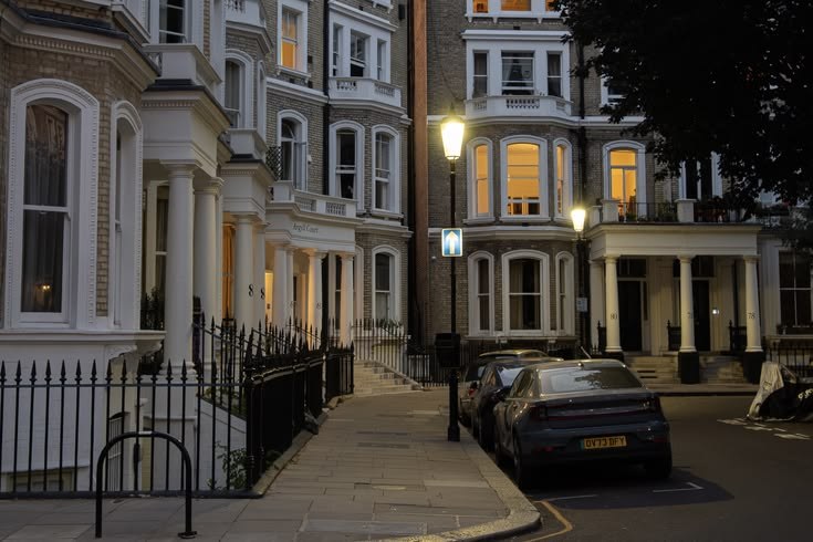 A quiet residential street after dark: the calm side of London's global real-estate brand.
