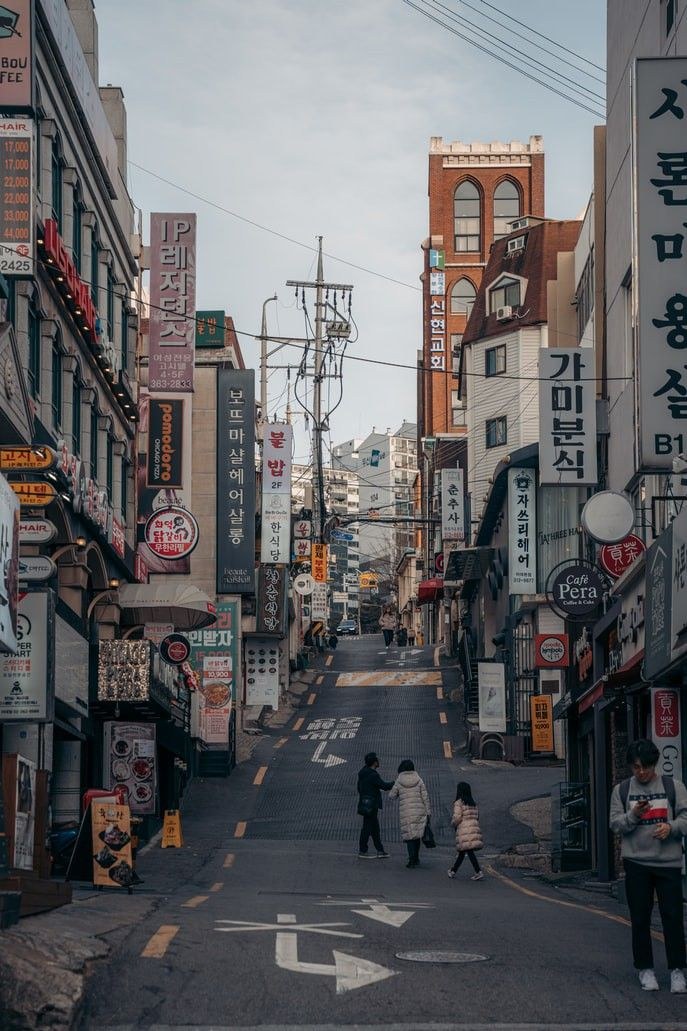 Commercial streets, signs and hills reveal the everyday density beneath Seoul's investment-grade skyline.
